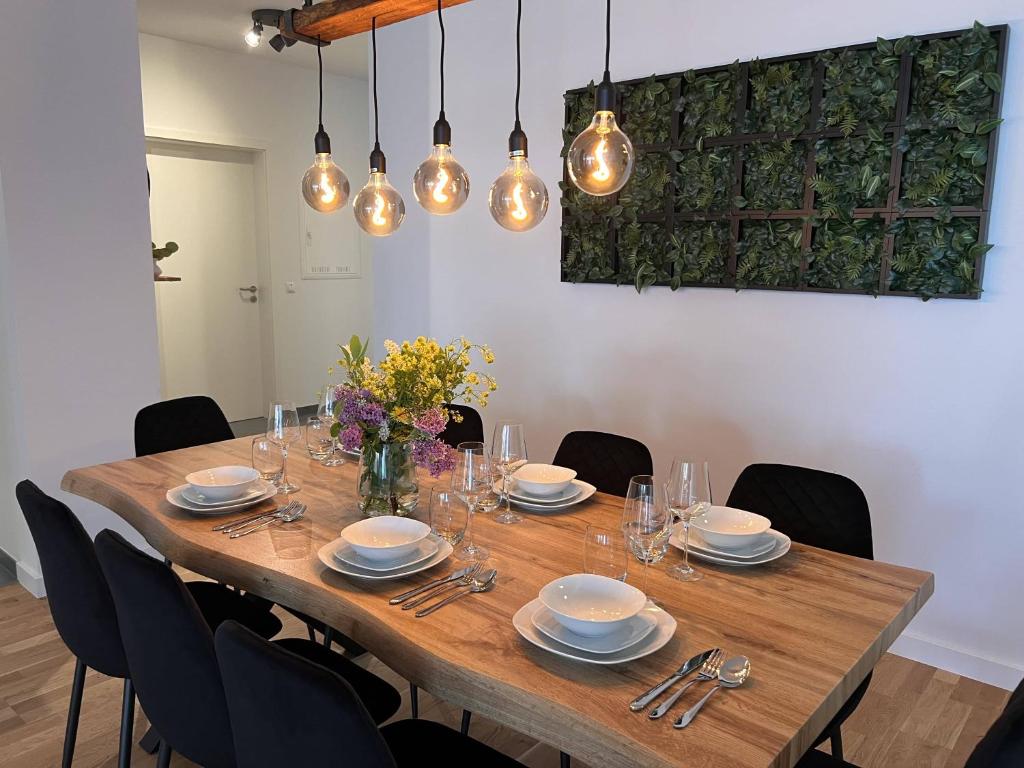 a dining room table with chairs and lights at KeyHosting Apartment Zentral Parkplatz in Aschaffenburg