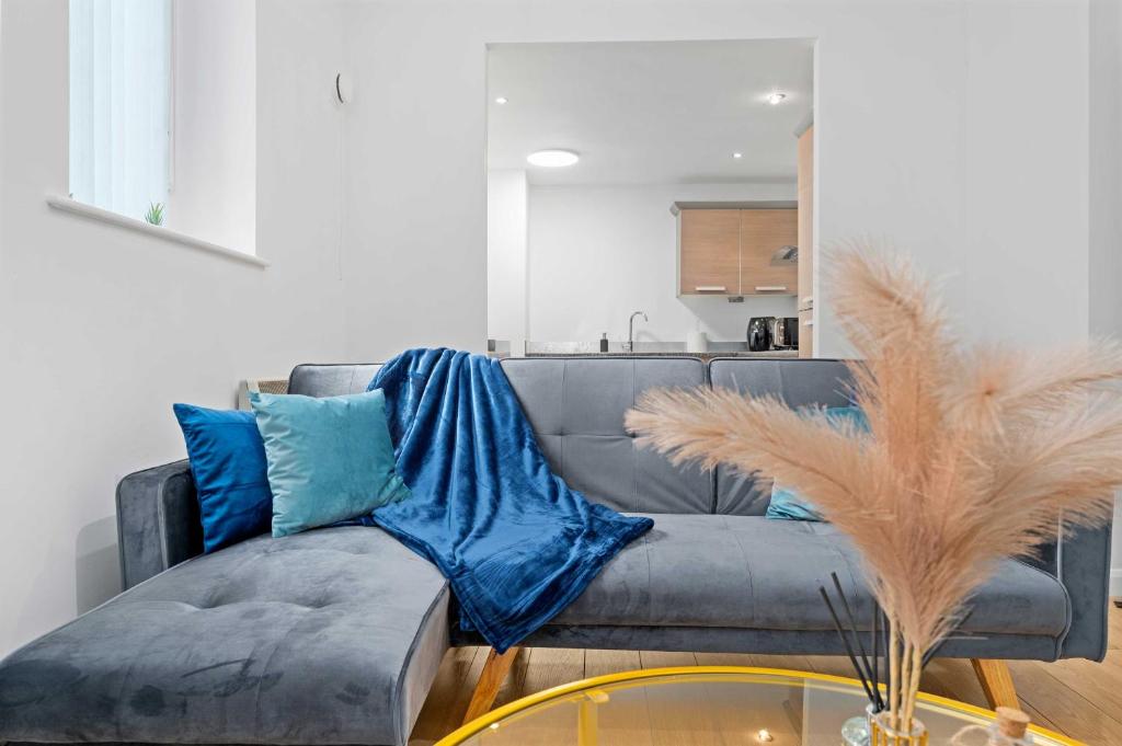 a living room with a gray couch with blue pillows at Modern 2Bed Northern Quarter, Long Stays, Contractors in Manchester