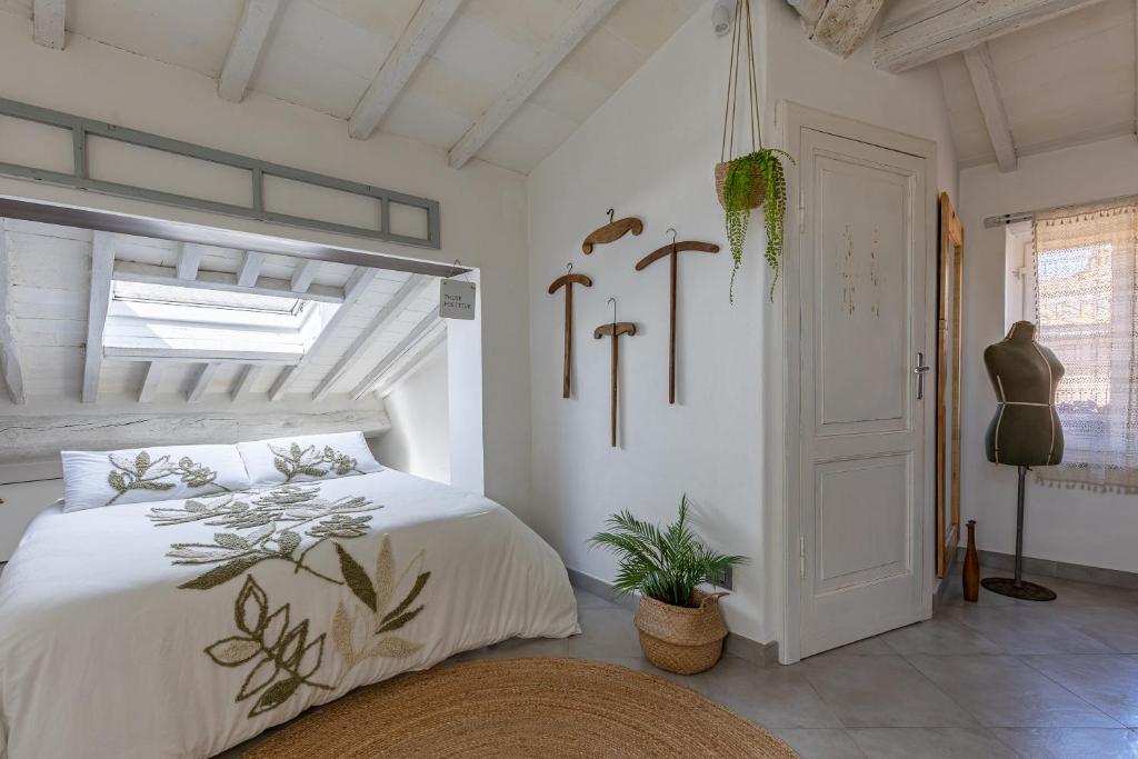 1 dormitorio con cama blanca y ventana en Il Nido, en Buonconvento