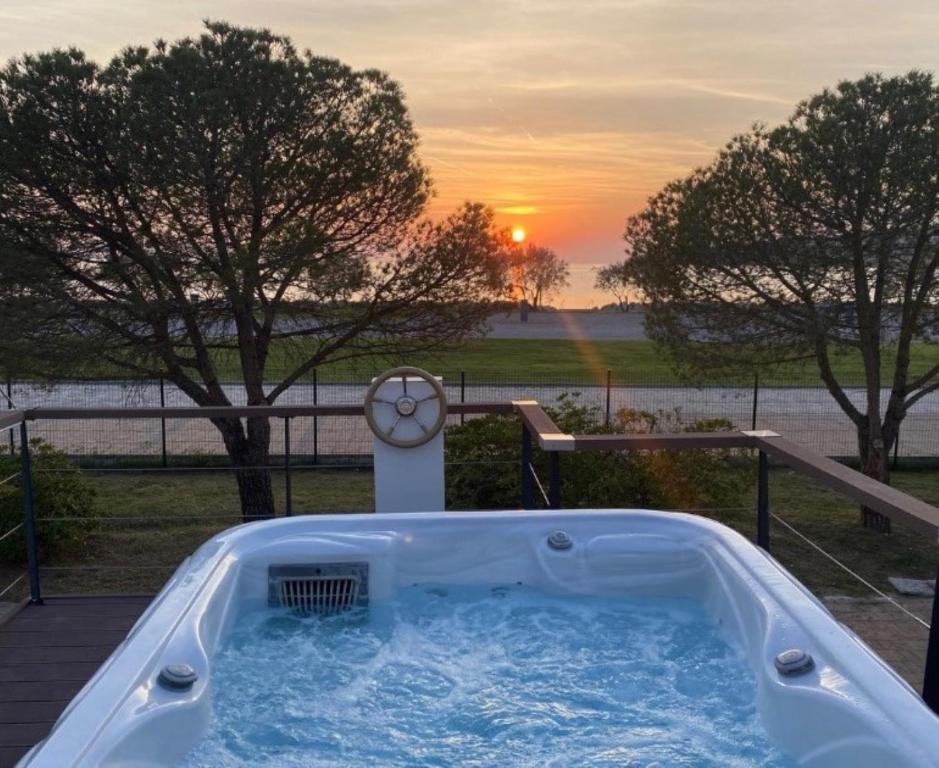 a jacuzzi tub with a sunset in the background at Sunset Joy in Portorož