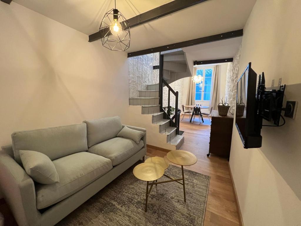 un salon avec un canapé et un escalier dans l'établissement La maisonnette - Atypique / Tout équipé !, à Nîmes