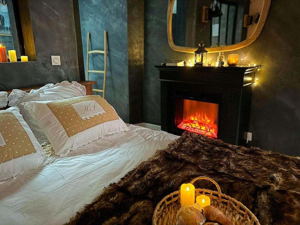 a bedroom with a bed with a fireplace and a mirror at Le chalet romantique, SPA, Écran cinéma, Lit king size, day use, 10 min centre in Amiens