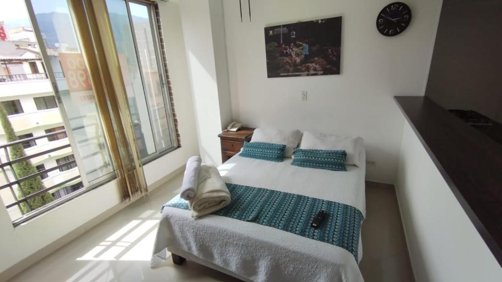 a bedroom with a bed and a large window at ApartaHotel Montes Medellin in Medellín