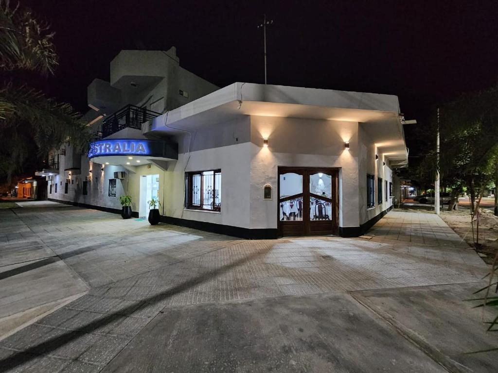 a building with a sign on the side of it at night at Hotel Australia in Termas de Río Hondo