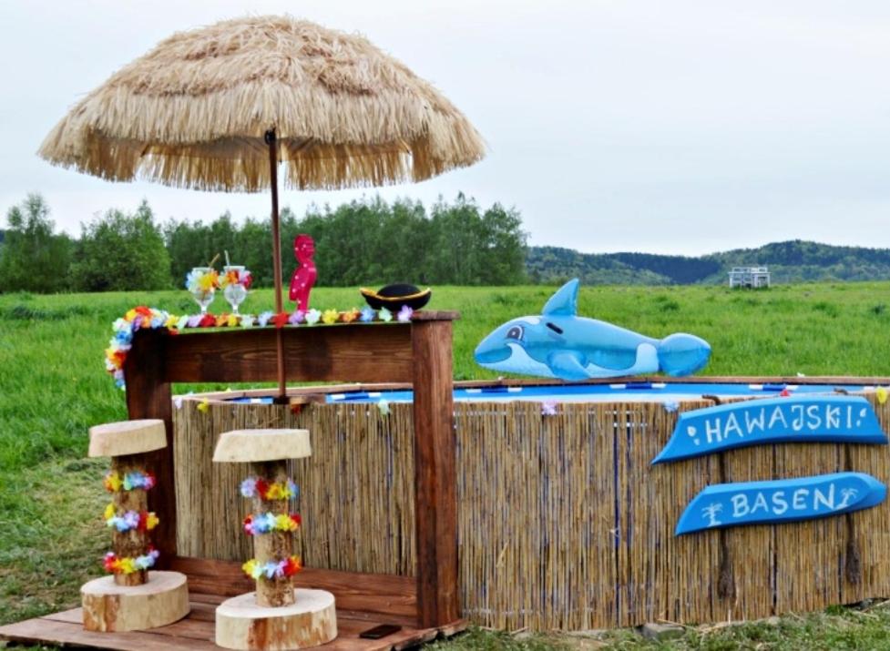 eine Bar mit einem Regenschirm und einem Haifischbecken in der Unterkunft Niesamowita Dolina 