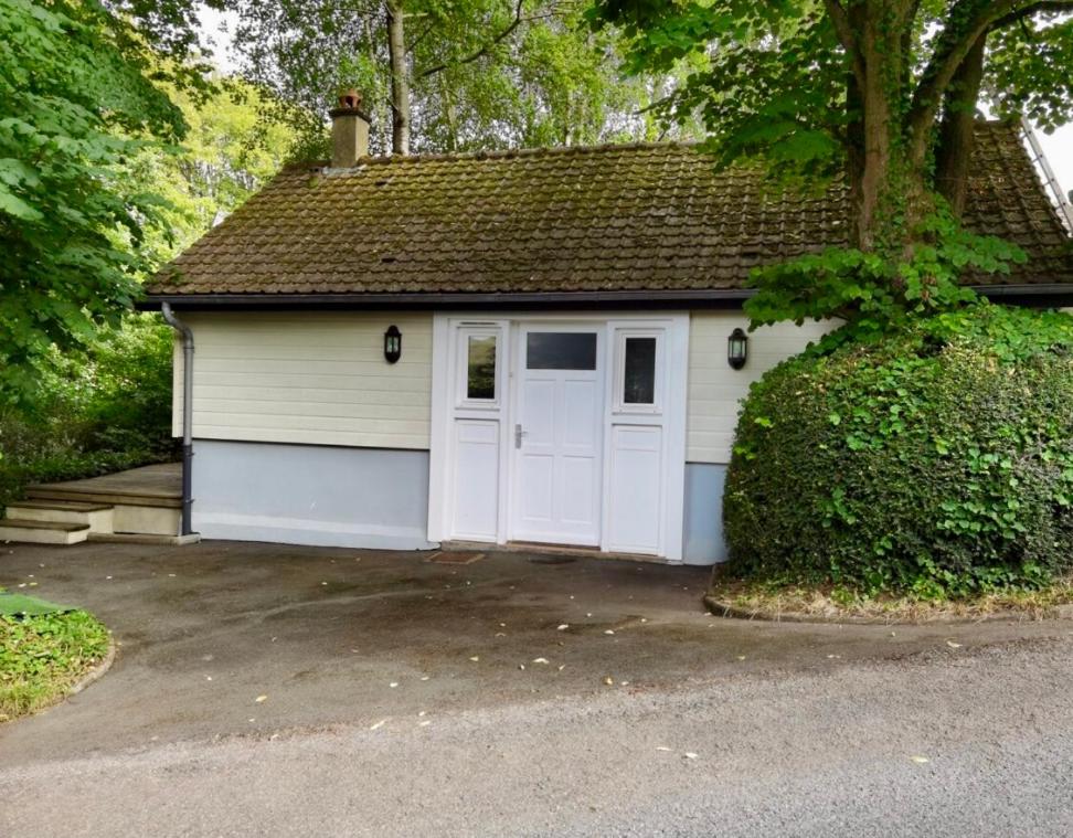 un petit garage blanc avec une porte blanche dans l'établissement Gîte vallée du denacre entre terre et mer, à Wimille
