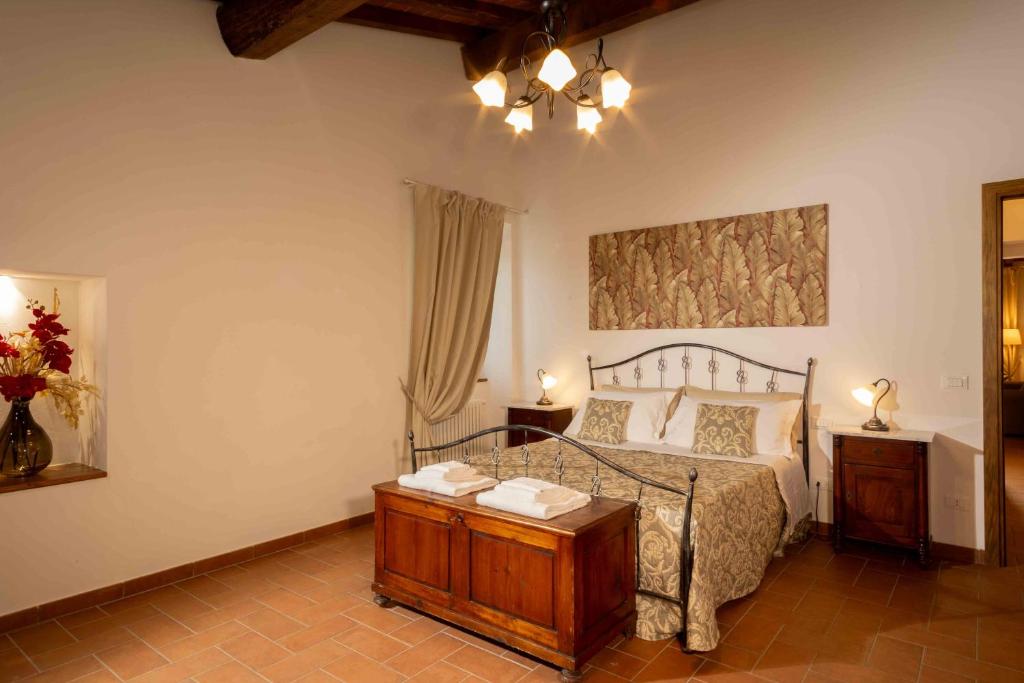 ラストラ・ア・シーニャにあるAzienda Agricola I Colli di Marlianoのベッドルーム1室(大型ベッド1台、木製テーブル付)