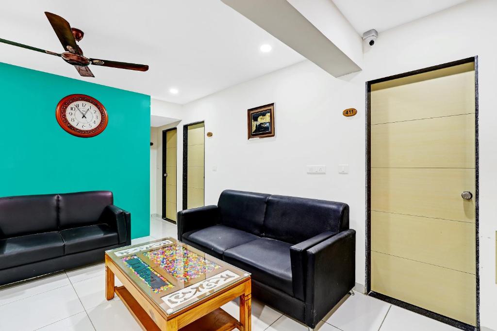 ein Wohnzimmer mit zwei schwarzen Ledersofas und einem Tisch in der Unterkunft Collection O Hotel La Veera in Ahmedabad