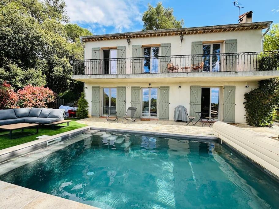 une maison avec une piscine devant une maison dans l'établissement Bastide de charme sous les pins avec piscine, à Saint-Paul-de-Vence
