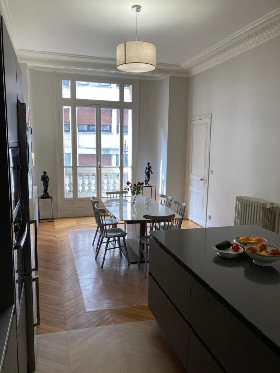 une cuisine et une salle à manger avec une table et des chaises dans l'établissement Appartement de standing, à Paris