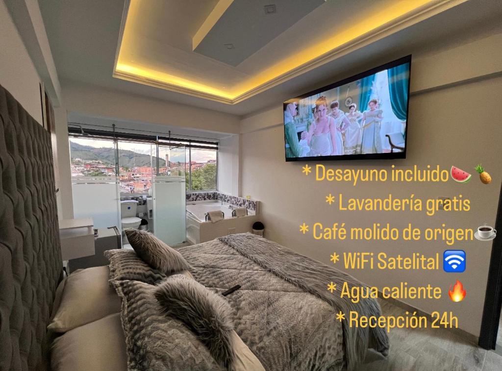 een slaapkamer met een bed en een tv aan de muur bij Hotel Casa Blanca in Aguadas