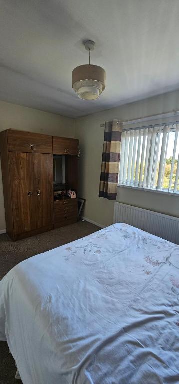 una camera con letto, cassettiera e finestre di Room to rent a Belfast