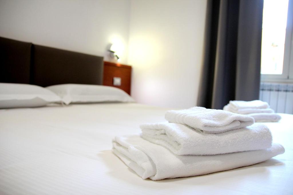 três toalhas empilhadas numa cama num quarto de hotel em Principe Guesthouse powered by Joyful Guesthouse em Roma