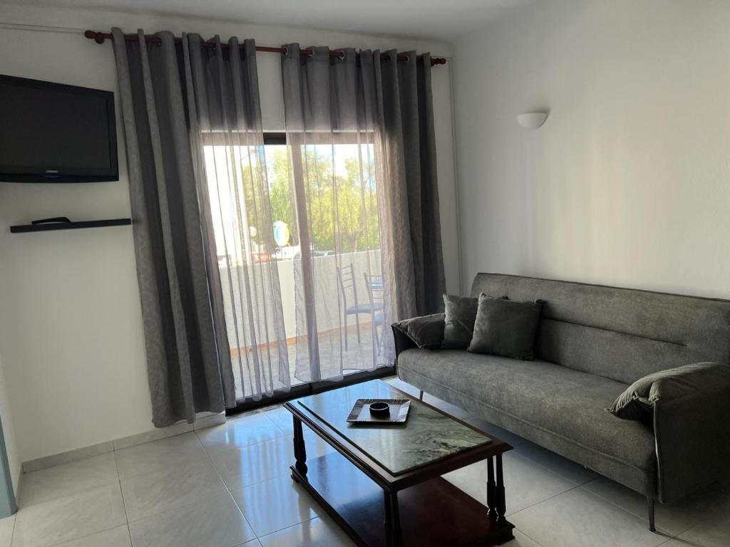 een woonkamer met een bank en een salontafel bij Apartamento Sunny in Albufeira