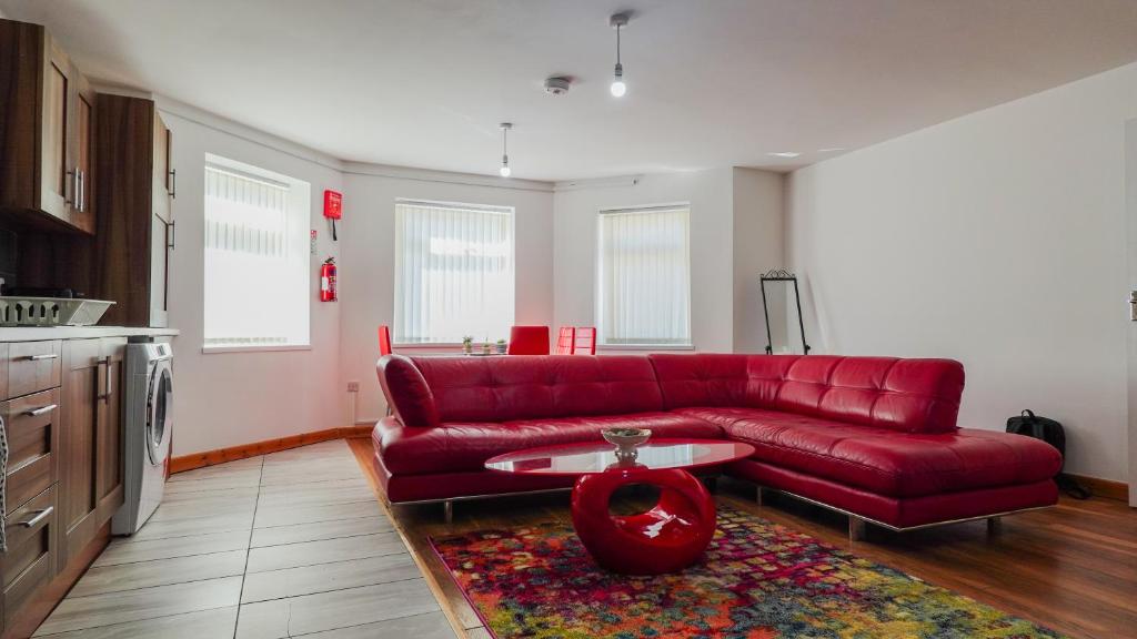 - un salon avec un canapé rouge et une table dans l'établissement The StayLuxe Apartment Manchester, à Manchester