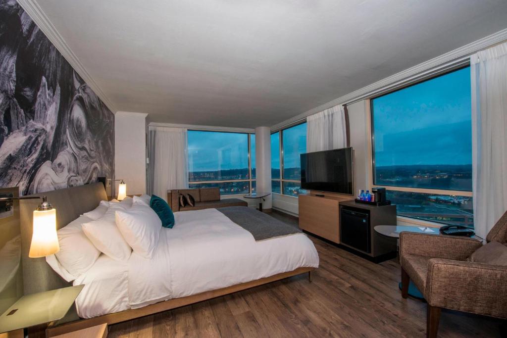 a bedroom with a large bed and large windows at Minneapolis Marriott Southwest in Minnetonka