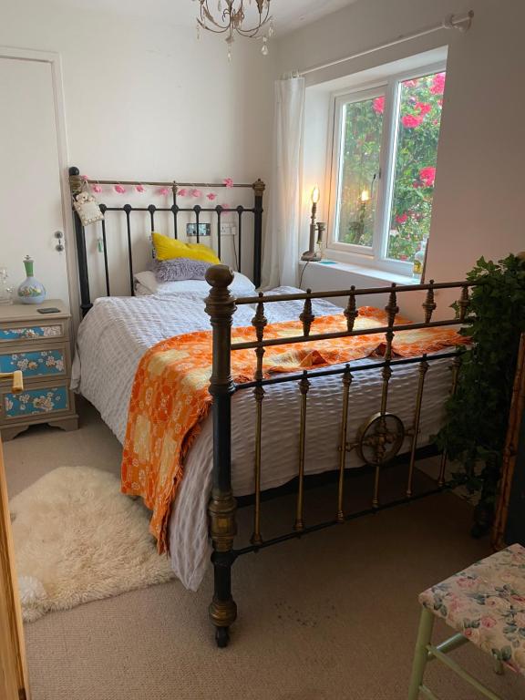 1 dormitorio con 1 cama con edredón naranja y blanco en Tamarisk en Clyro