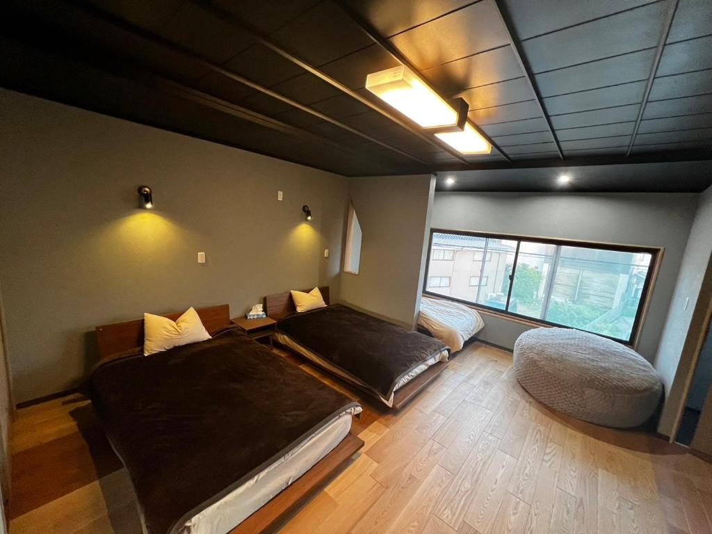 Zimmer mit 2 Betten und einem Fenster in der Unterkunft 貸し切りゲストハウスsai2nd in Yasugi