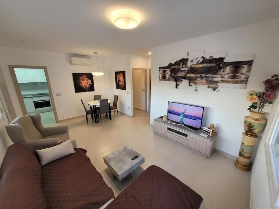 a living room with a couch and a flat screen tv at Chalet adosado acogedor Busot in Alicante