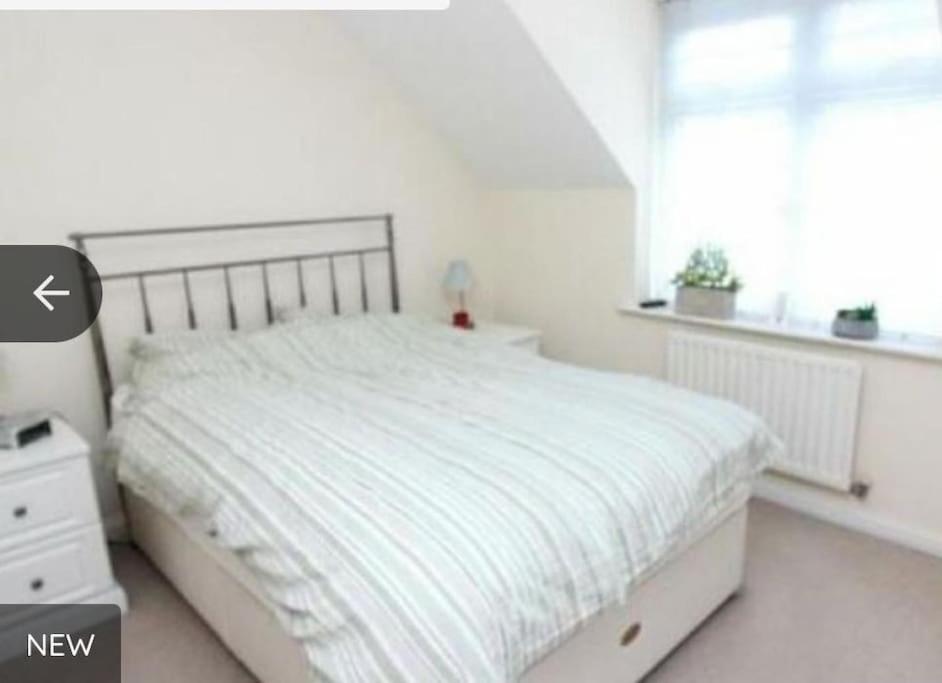Habitación blanca con cama y ventana en Dengenzii Spacious 1 bed apartment, en Leeds