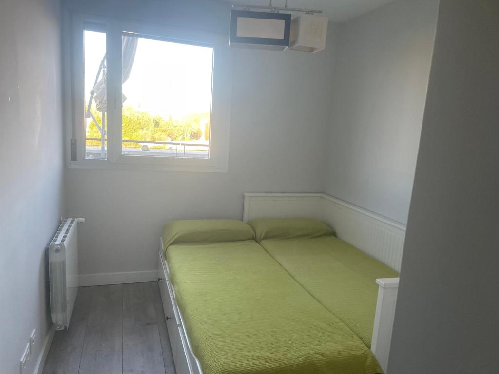 ein kleines Schlafzimmer mit einem Bett und einem Fenster in der Unterkunft Apartamento Cervantino in Alcalá de Henares
