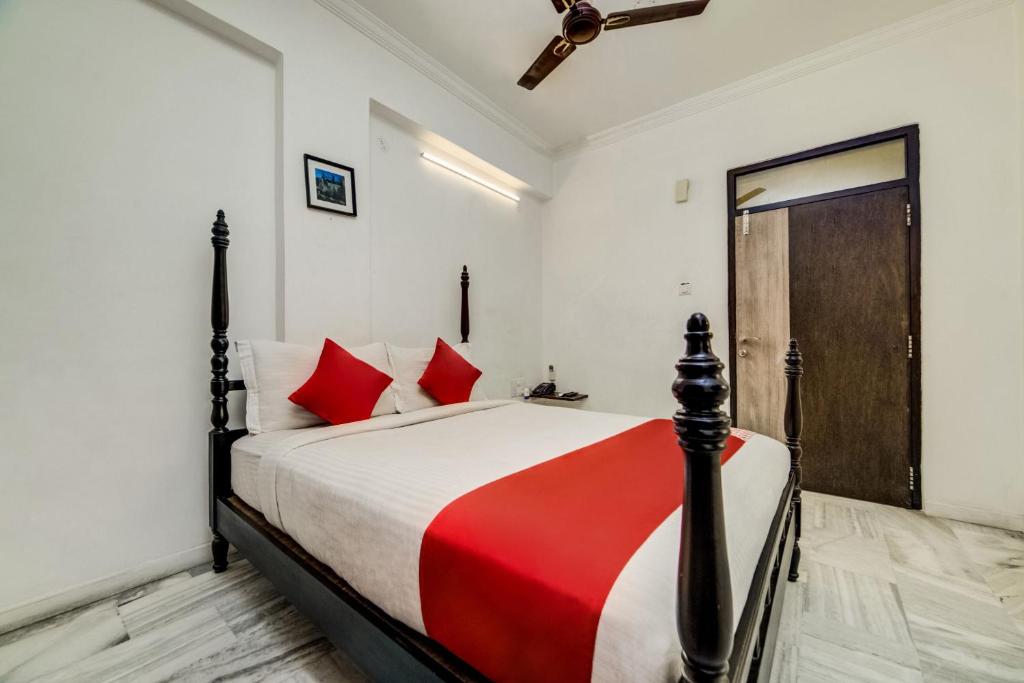 - une chambre avec un grand lit et des oreillers rouges dans l'établissement Super OYO JNTU college Near LULU mall, KPHB Colony., à Kukatpally