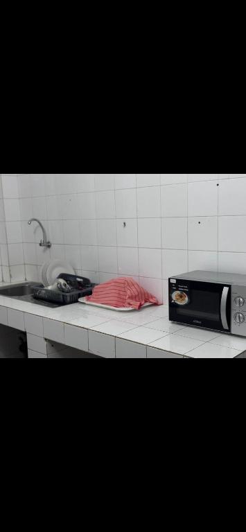 a kitchen counter with a stove and a microwave at Joli appartement ngor / Almadies in Ngor