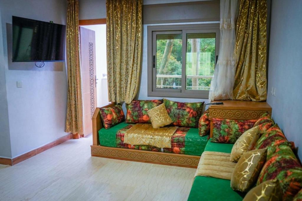 sala de estar con sofá y ventana en شقق العمري أقشور شفشاون, en Akchour