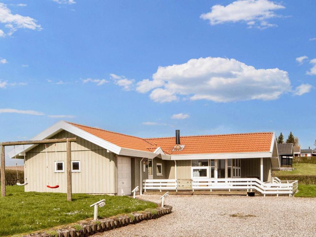 een klein huis met een oranje dak op een veld bij Two-Bedroom Holiday home in Kalundborg 2 in Børkop