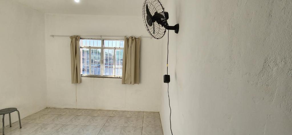 a white room with a fan on the wall at Kitinet aconchegante em Nova Iguaçu in Nova Iguaçu