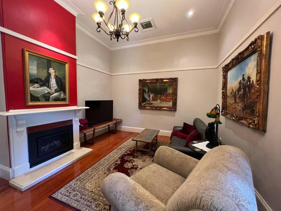 a living room with a couch and a fireplace at The Bank House in Mount Victoria