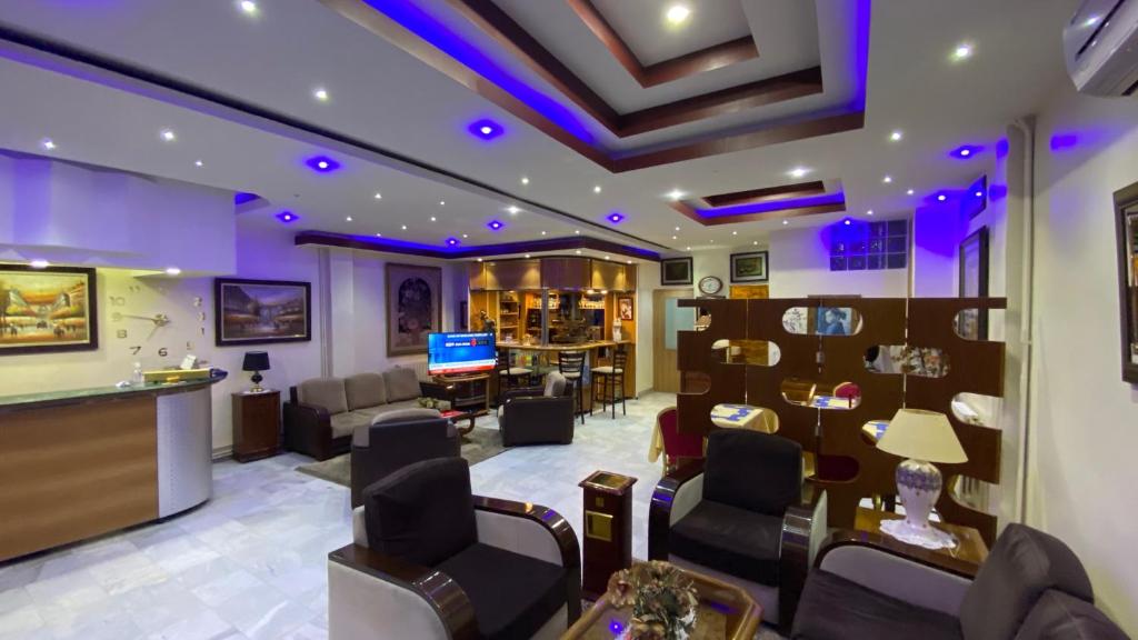 un salón con una sala de espera con iluminación púrpura en Hôtel le convivial, en Jijel