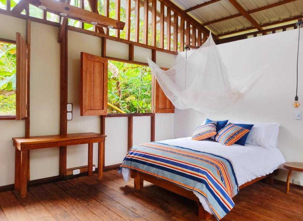 um quarto com uma cama num quarto com janelas em Reserva Pakore Wera em Bahía Solano