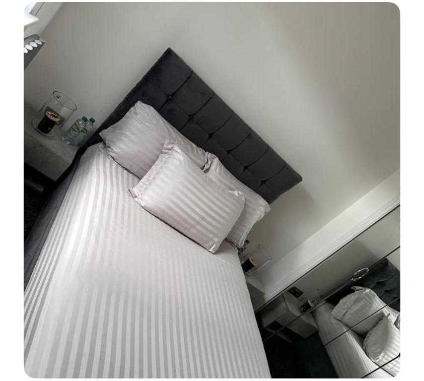 a bed with white sheets and pillows on it at Giles Apart in Edinburgh