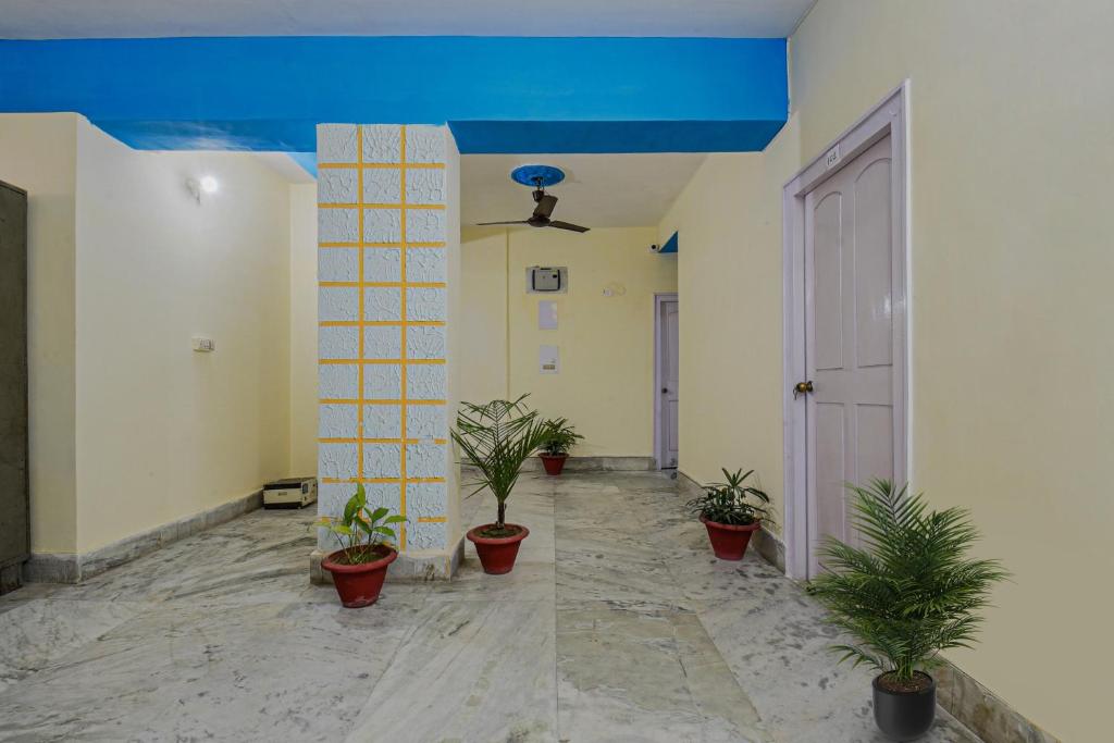 un pasillo con macetas y techo azul en OYO Vibrant Inn en Patna