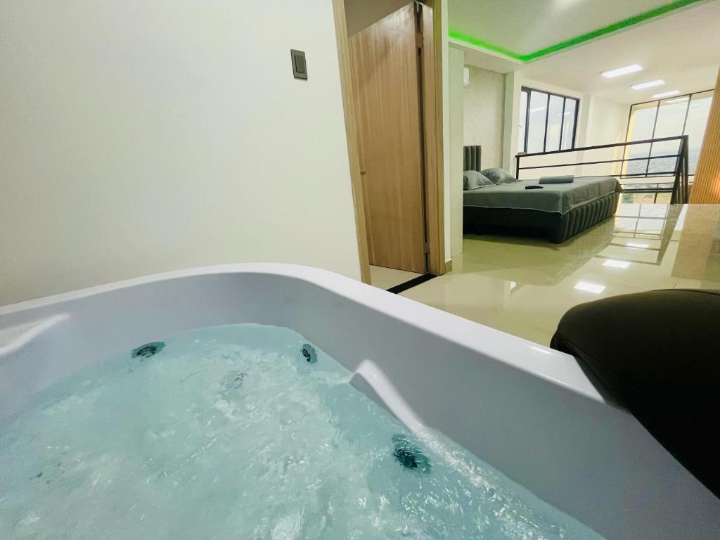 a bath tub filled with water in a living room at Vista Hills Loft & Jacuzzi in Guayaquil
