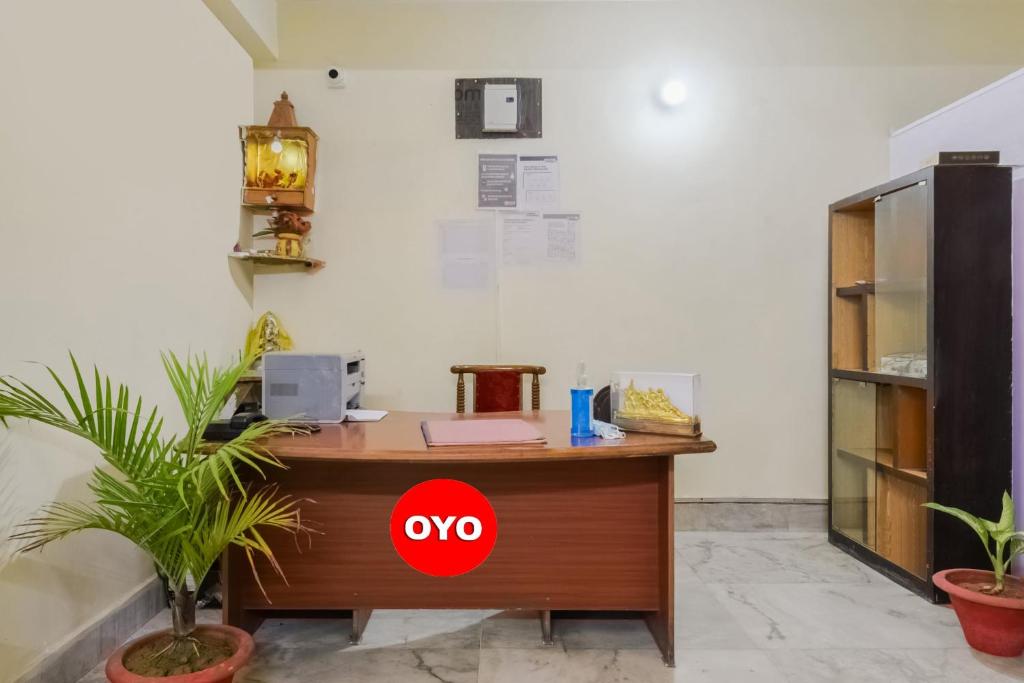 un ufficio con scrivania in legno e scatola rossa di OYO Vibrant Inn a Patna