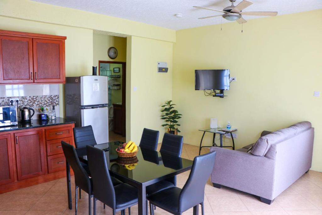 a kitchen and dining room with a table and a couch at Hidden Gem Apartments (No.5) in Castries
