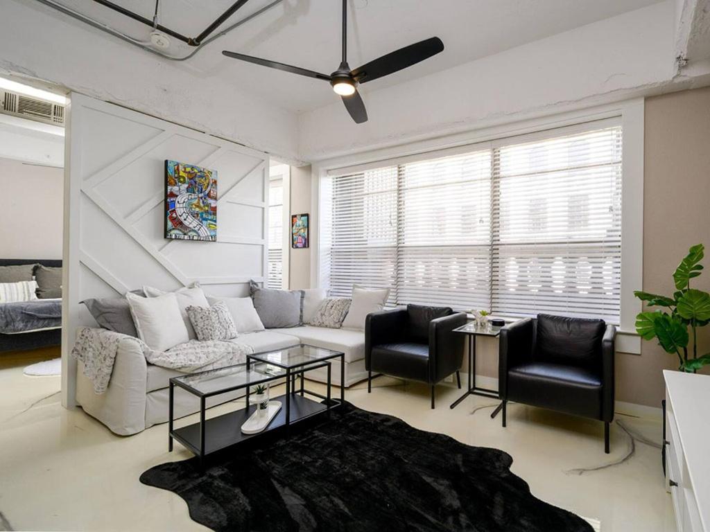 a living room with a couch and chairs and a ceiling fan at Downtown Memphis Luxury Condo in Memphis