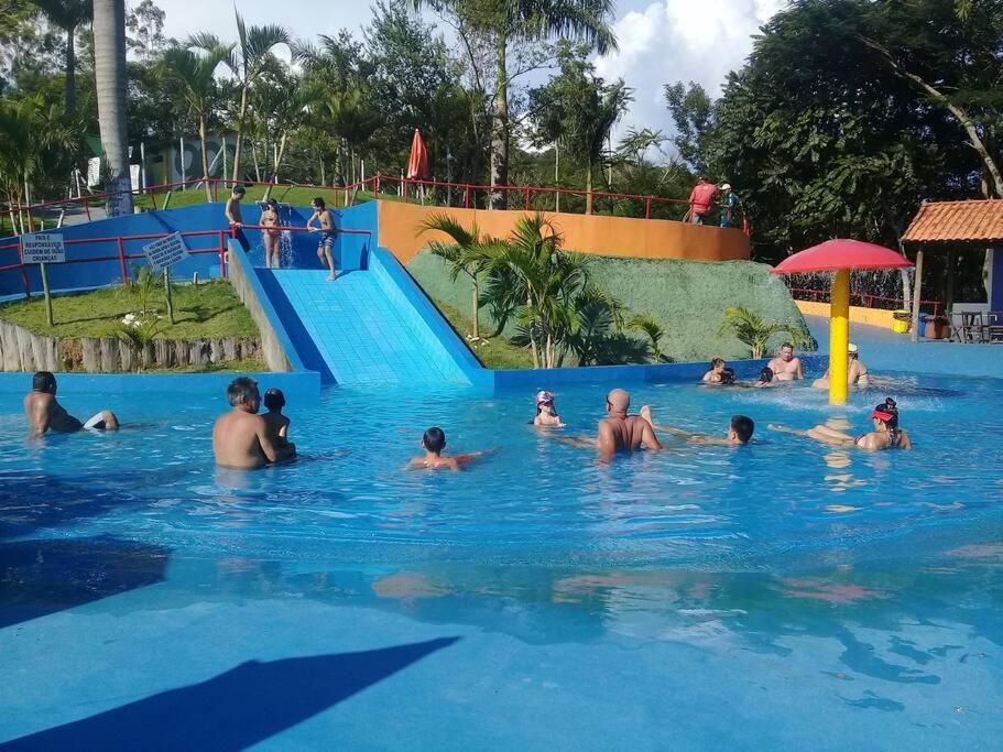 a group of people in the water at a water park at Casa Centenária localizada no calçadão de SLP in São Luiz do Paraitinga