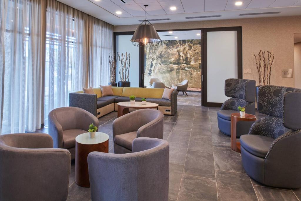 a waiting room with couches and chairs and tables at Courtyard by Marriott Petoskey at Victories Square in Petoskey
