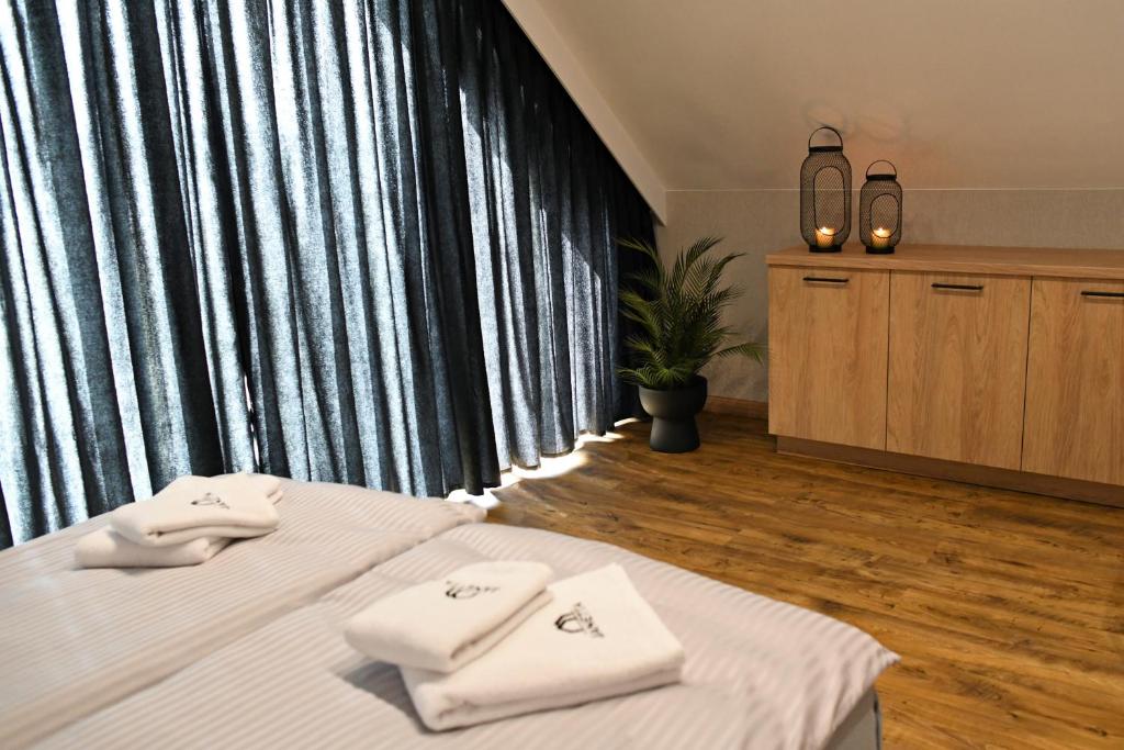 une chambre avec un lit avec des serviettes blanches dessus dans l'établissement APARTAMENT JANETTA domek nad jeziorem, à Stężyca