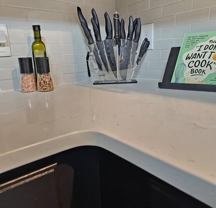 a counter with a bunch of knives and a bottle of wine at Atlantic City Bungalow Retreat in Atlantic City