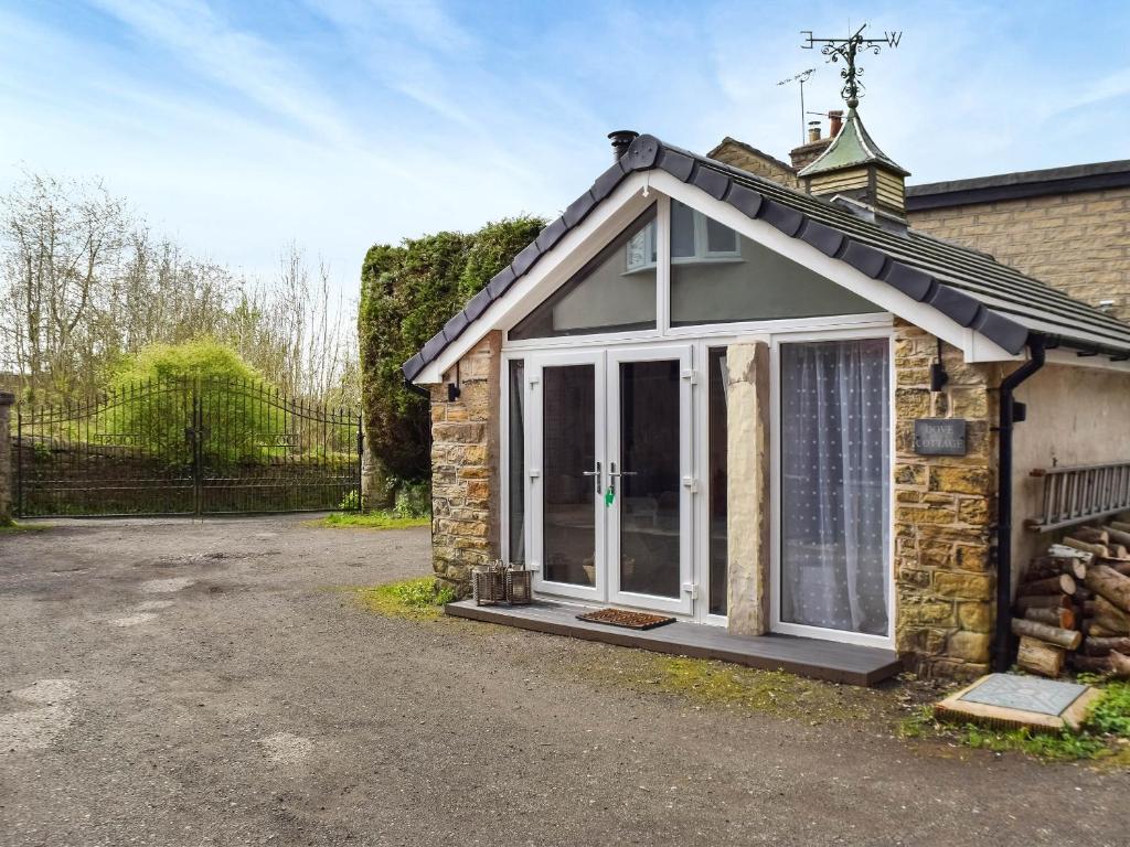 a detached stone cottage with a large sliding glass door at Dove House 