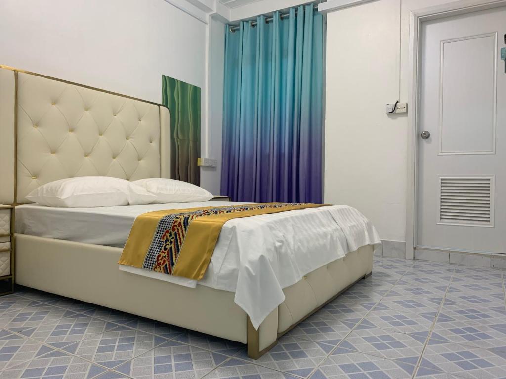 Ontrack Travel Transit Hotel في مدينة ماليه: غرفة نوم بسرير كبير مع اللوح الأمامي كبير