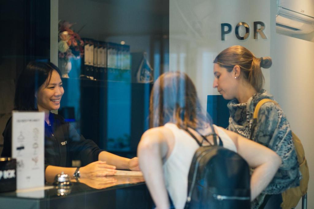 Guests speak with a receptionist at the hotel’s front desk.