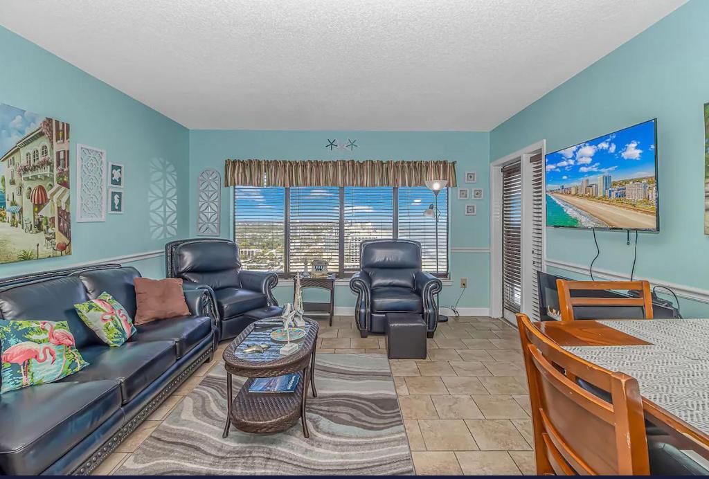 ein Wohnzimmer mit einem Sofa, Stühlen und einem Tisch in der Unterkunft Luxurious Ocean view Queen Suite - With New LED Fireplace! Palace Resort Unit 2210 in Myrtle Beach