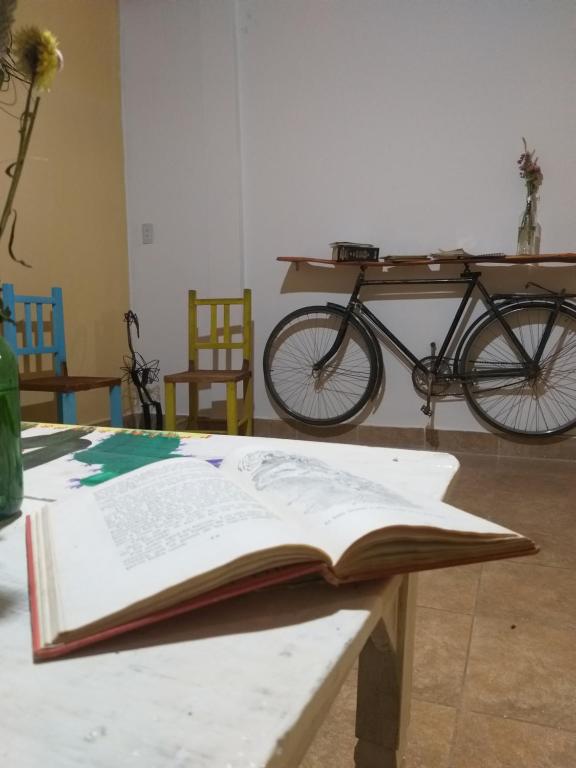 um livro aberto sobre uma mesa com uma bicicleta ao fundo em El Mollecito Hostel em Humahuaca