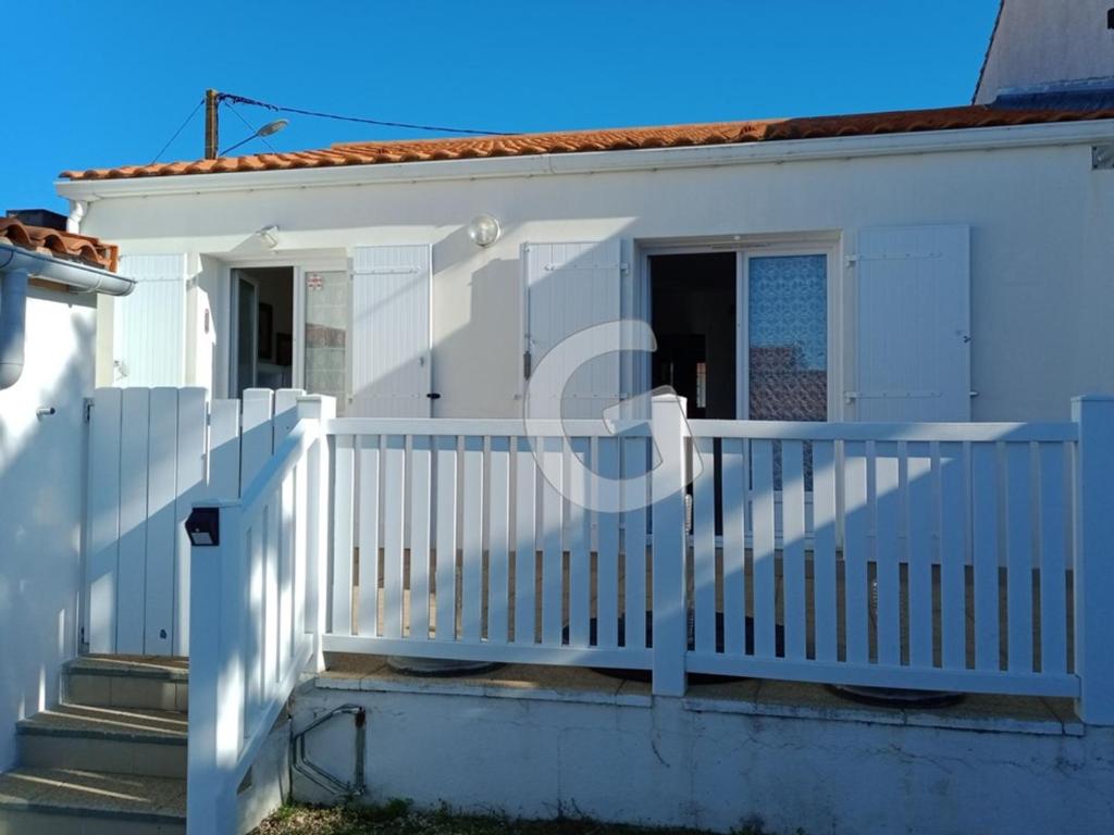 une maison blanche avec une clôture blanche dans l'établissement Maison 5 pers. à La Tranche sur Mer, Proche Plage, Terrasse, Garage, Dordonnée - FR-1-357-109, à La Tranche-sur-Mer