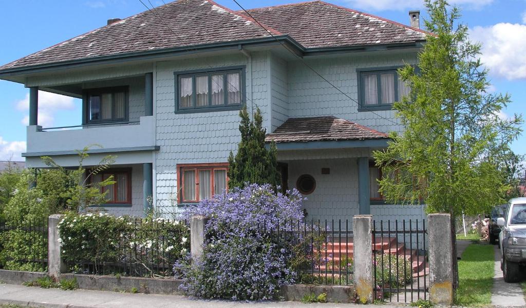 a white house with a fence in front of it at Tradicion Austral Bed & Breakfast in Puerto Varas